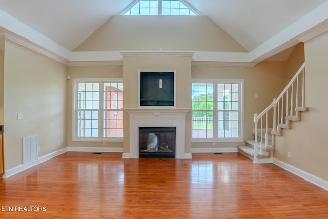 1419 Cheyenne Blvd, Seymour, TN 37865 - unfurnished living room featuring vaulted ceiling, light wood-style flooring, healthy amount of natural light, a glass covered fireplace, and stairs