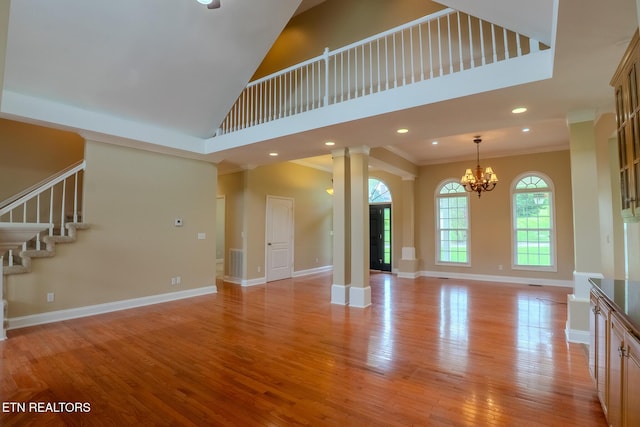 1419 Cheyenne Blvd, Seymour, TN 37865 - unfurnished living room with decorative columns, light wood finished floors, crown molding, stairs, and a towering ceiling