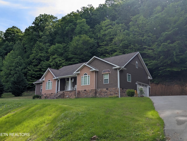 900 Twin Fawn Trl, Middlesboro, KY 40965 - view of front of property featuring driveway, covered porch, a front lawn, an attached garage, and a wooded view