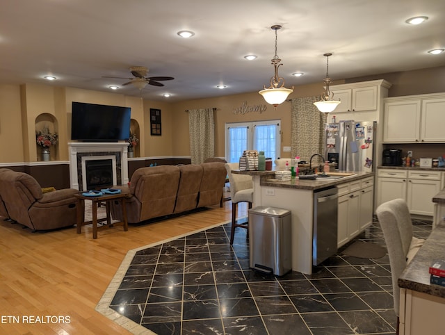 900 Twin Fawn Trl, Middlesboro, KY 40965 - kitchen with open floor plan, stainless steel appliances, a sink, a ceiling fan, and white cabinetry
