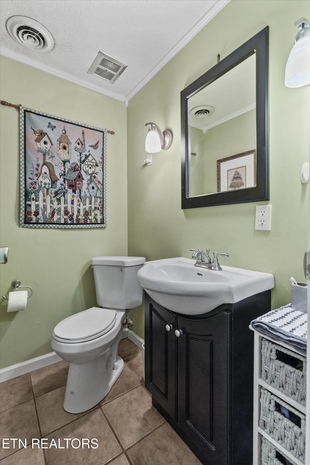 bathroom with crown molding, baseboards, tile patterned floors, toilet, and vanity