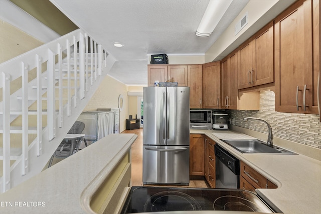 kitchen with stainless steel appliances, a sink, light countertops, decorative backsplash, and brown cabinets