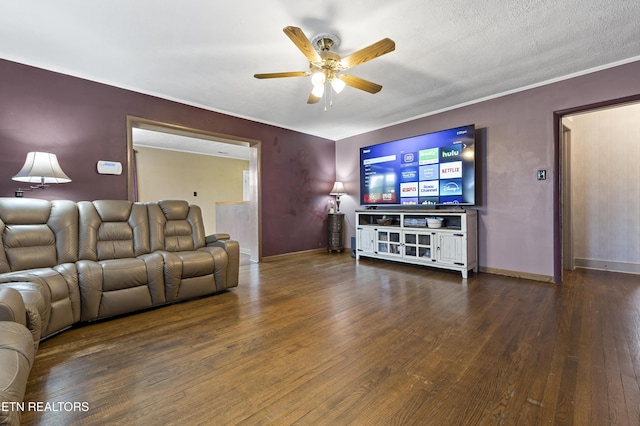 living area featuring a ceiling fan, dark wood-style floors, baseboards, and crown molding