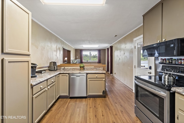 kitchen with appliances with stainless steel finishes, light wood finished floors, a peninsula, ornamental molding, and cream cabinets