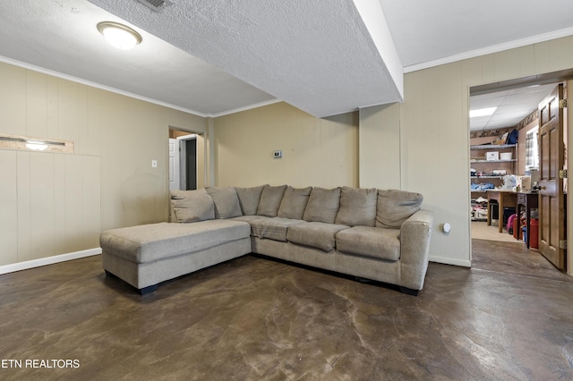 living area with concrete flooring, ornamental molding, and baseboards