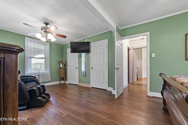 sitting room featuring ornamental molding, baseboards, dark wood-style flooring, ceiling fan, and a textured ceiling
