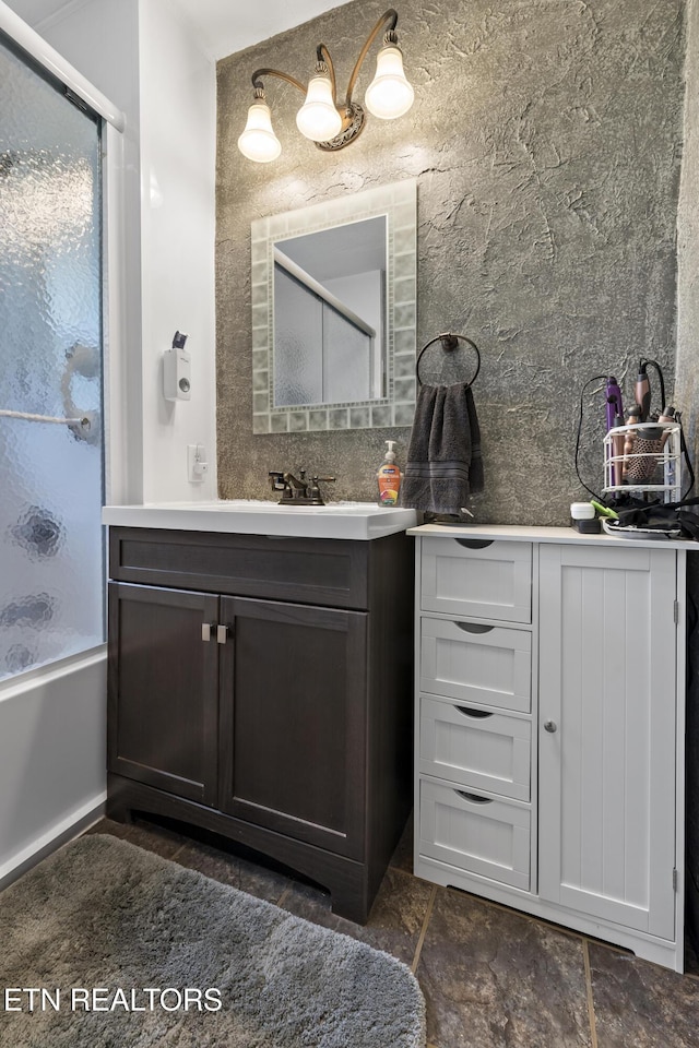 bathroom with vanity and bath / shower combo with glass door