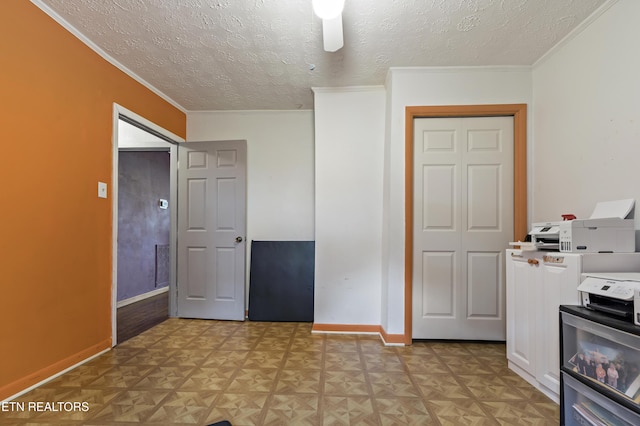 kitchen featuring a textured ceiling, baseboards, ornamental molding, white cabinets, and light countertops