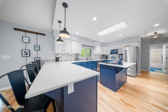 118 Motthaven Dr, Crossville, TN 38558 - kitchen featuring stainless steel appliances, a breakfast bar, a peninsula, light countertops, and recessed lighting