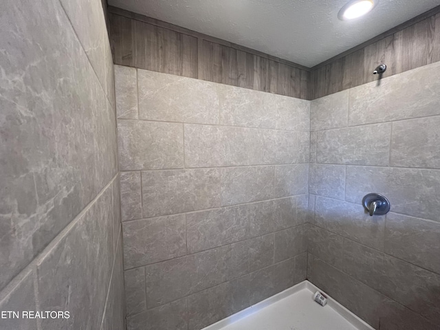 225 Orange Ln, Speedwell, TN 37870 - bathroom featuring a tile shower and a textured ceiling