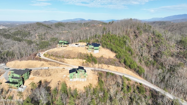aerial overview of property's location featuring a forest and mountains