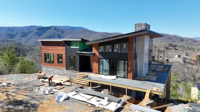 rear view of house with a mountain view and a chimney