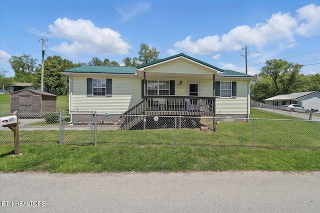 138 Robinson Ln, Middlesboro, KY 40965 - view of front facade featuring a porch, a storage unit, an outbuilding, and metal roof