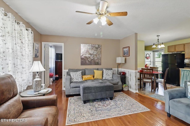 138 Robinson Ln, Middlesboro, KY 40965 - living room featuring light wood-type flooring, a chandelier, ceiling fan, and wainscoting