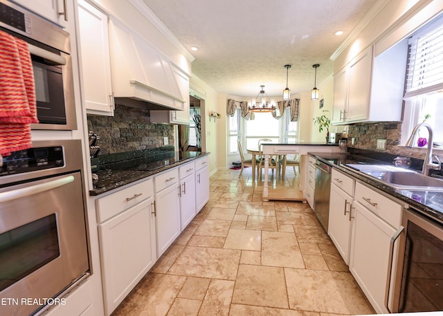 112 Chestnut Hill Rd, Oak Ridge, TN 37830 - kitchen with stainless steel appliances, a sink, a chandelier, stone tile floors, and beverage cooler