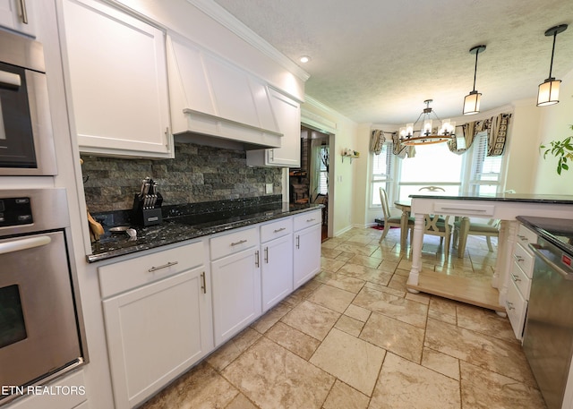 112 Chestnut Hill Rd, Oak Ridge, TN 37830 - kitchen with appliances with stainless steel finishes, a chandelier, backsplash, white cabinetry, and stone tile floors