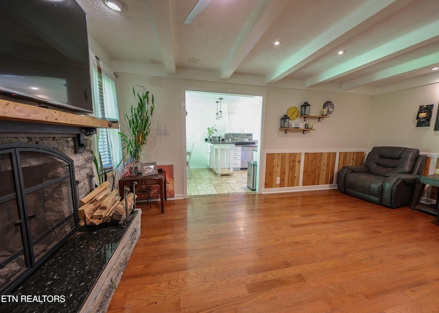112 Chestnut Hill Rd, Oak Ridge, TN 37830 - living room featuring beamed ceiling, wood finished floors, a stone fireplace, wainscoting, and recessed lighting