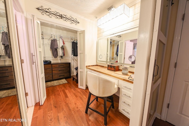 112 Chestnut Hill Rd, Oak Ridge, TN 37830 - bathroom featuring crown molding, wood finished floors, a textured ceiling, and a walk in closet