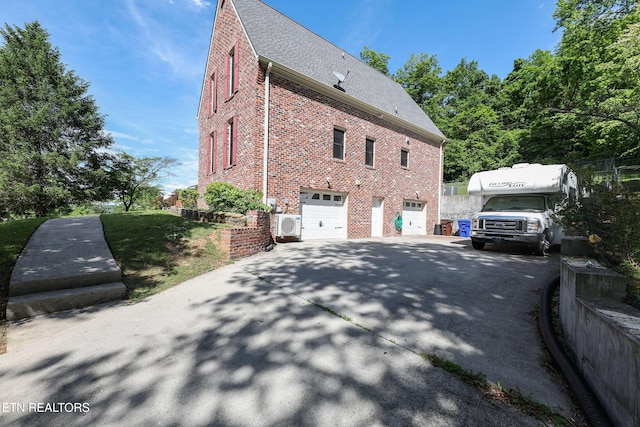 112 Chestnut Hill Rd, Oak Ridge, TN 37830 - view of side of property with brick siding, a garage, a shingled roof, and concrete driveway