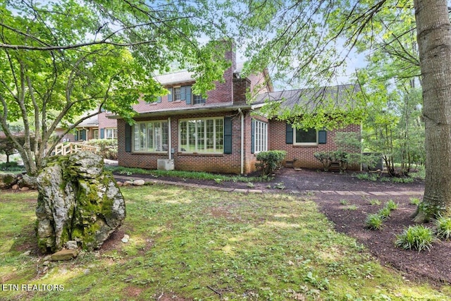 rear view of property with brick siding