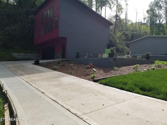 667 Turkey Nest Rd, Gatlinburg, TN 37738 - view of side of property with a garage, driveway, stone siding, and fence