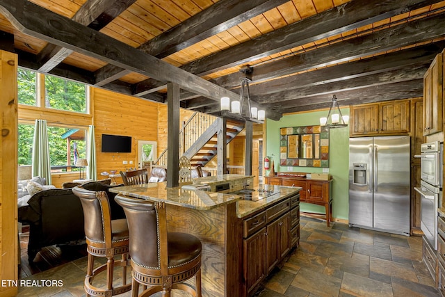529 Deer Path Ln, Gatlinburg, TN 37738 - kitchen with stainless steel appliances, open floor plan, stone tile floors, stone countertops, and a kitchen breakfast bar