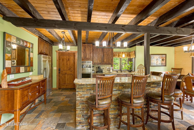 529 Deer Path Ln, Gatlinburg, TN 37738 - kitchen with appliances with stainless steel finishes, stone tile floors, tasteful backsplash, light stone counters, and wooden ceiling with exposed beams