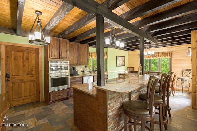 529 Deer Path Ln, Gatlinburg, TN 37738 - kitchen featuring stone tile flooring, stainless steel appliances, wood ceiling with exposed beams, brown cabinetry, and light stone countertops