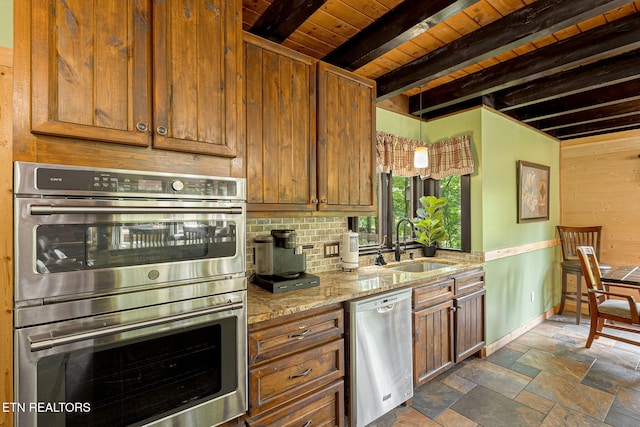 529 Deer Path Ln, Gatlinburg, TN 37738 - kitchen with appliances with stainless steel finishes, a sink, brown cabinets, stone tile floors, and baseboards
