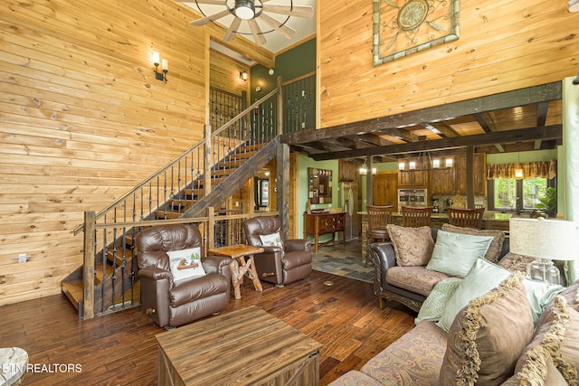529 Deer Path Ln, Gatlinburg, TN 37738 - living area featuring a high ceiling, wood walls, hardwood / wood-style flooring, stairs, and a ceiling fan