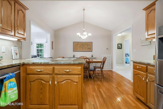 157 Garfield Ct, Crossville, TN 38558 - kitchen with light wood-style floors, a peninsula, brown cabinetry, a chandelier, and vaulted ceiling