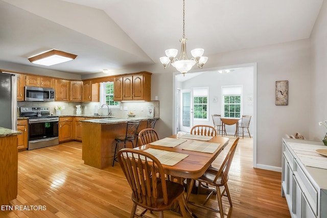 157 Garfield Ct, Crossville, TN 38558 - dining space with light wood finished floors, a chandelier, lofted ceiling, and baseboards