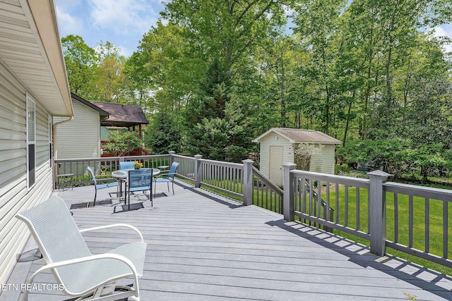 157 Garfield Ct, Crossville, TN 38558 - wooden terrace featuring outdoor dining space, a shed, an outbuilding, and a yard