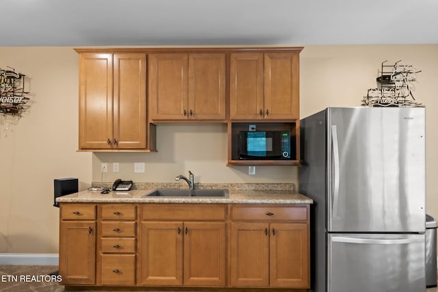 115 Tecumseh Ln, Loudon, TN 37774 - kitchen featuring freestanding refrigerator, black microwave, a sink, brown cabinetry, and light countertops