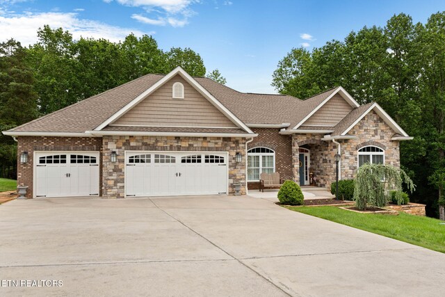 115 Tecumseh Ln, Loudon, TN 37774 - craftsman-style home with a garage, driveway, stone siding, and a shingled roof