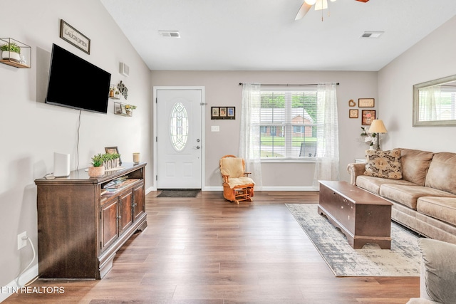 living room with healthy amount of natural light, a ceiling fan, wood finished floors, and baseboards