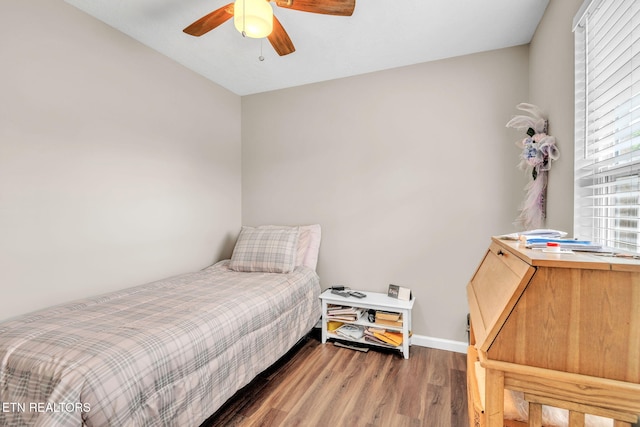 bedroom featuring wood finished floors, baseboards, and ceiling fan