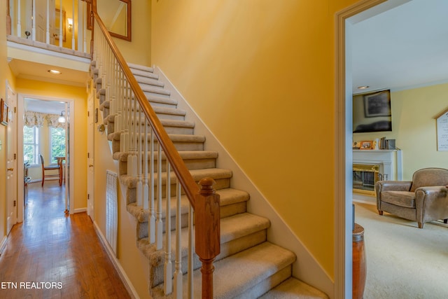 312 Cheestana Way, Loudon, TN 37774 - staircase featuring a glass covered fireplace, wood finished floors, baseboards, and ornamental molding
