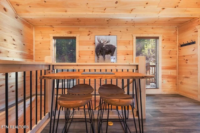dining room with wooden ceiling, wood walls, and wood finished floors