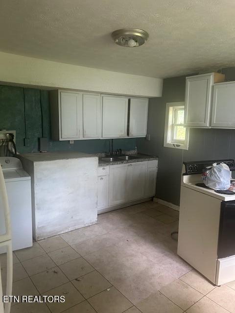 3614 Selma Ave, Knoxville, TN 37914 - kitchen featuring washer / dryer, a sink, white cabinetry, and a textured ceiling