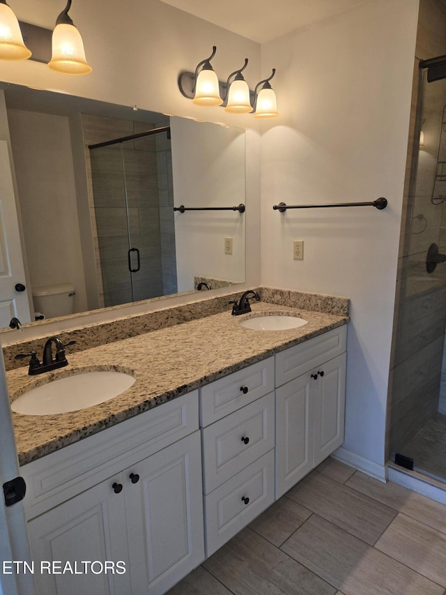678 Applegate Ln Unit 33, Knoxville, TN 37934 - full bathroom featuring a stall shower, toilet, double vanity, and wood tiled floors