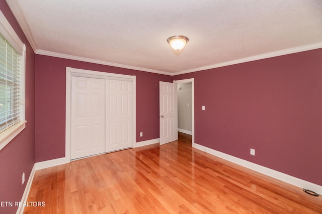 917 Swan Pond Circle Rd, Harriman, TN 37748 - unfurnished bedroom with light wood finished floors, a closet, baseboards, ornamental molding, and a textured ceiling