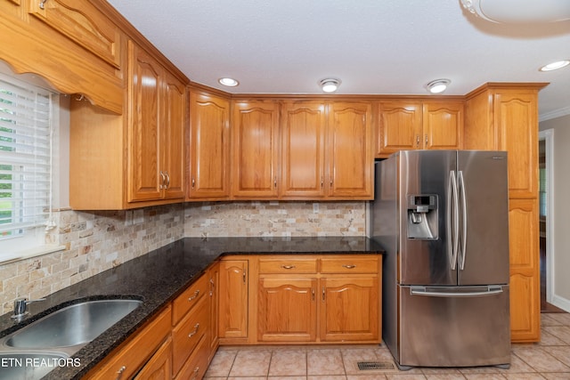 917 Swan Pond Circle Rd, Harriman, TN 37748 - kitchen featuring stainless steel refrigerator with ice dispenser, a sink, brown cabinets, dark stone counters, and light tile patterned floors