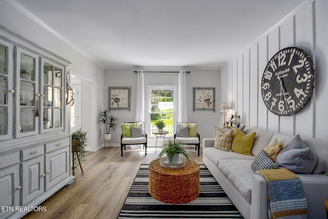 living area with light wood-style floors, ornamental molding, and baseboards
