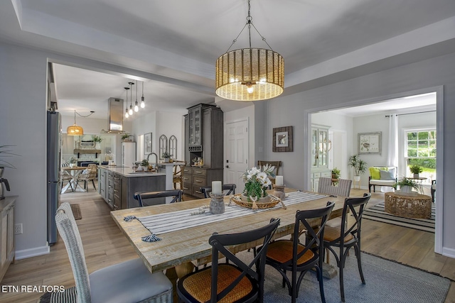 dining area featuring wood finished floors, a chandelier, and baseboards