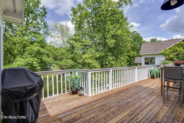 wooden deck featuring a grill
