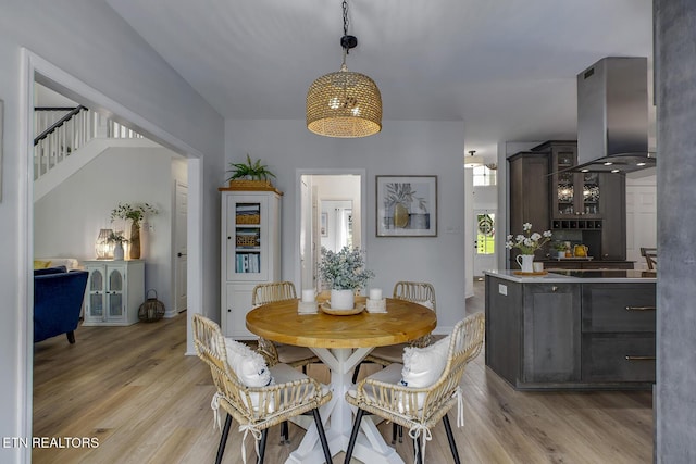 dining room featuring light wood-type flooring and stairway