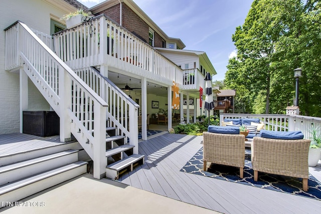 deck with an outdoor living space, stairs, and ceiling fan