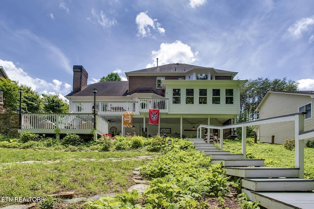 rear view of house featuring stairway, a chimney, and a deck