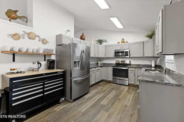 134 Jordan Dr, Caryville, TN 37714 - kitchen featuring appliances with stainless steel finishes, a sink, vaulted ceiling, gray cabinetry, and light wood-type flooring